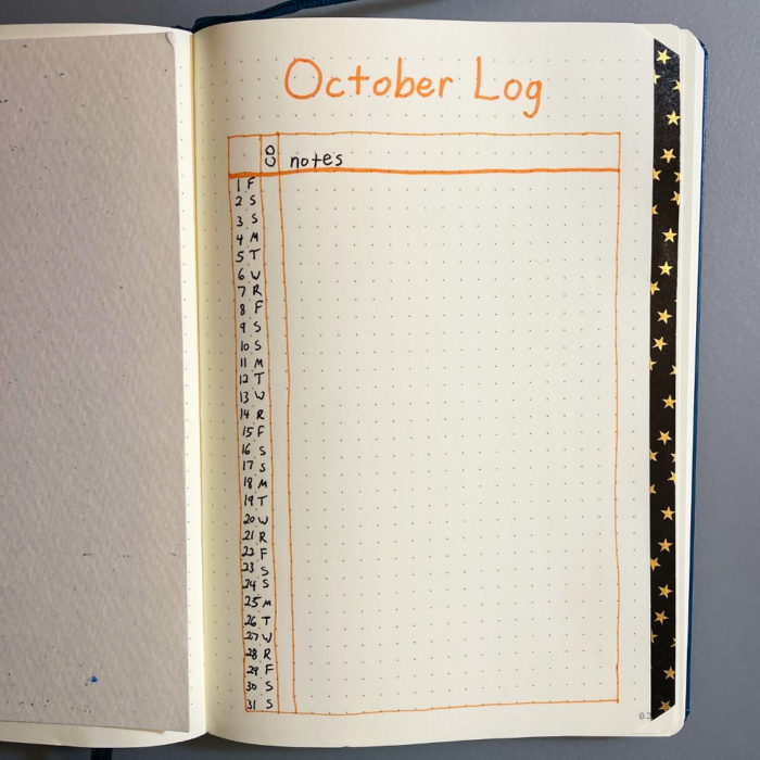 A journal page with a monthly log for October. The top of the page says, "October log." The log is outlined in Orange. Down the left side, days are listed (1-31) and abbreviations for days of the week. One column says "CO," for "creative output." The rest of the space is for notes. On the right side of the page, there's a strip of washi tape with a black background and small gold stars.
