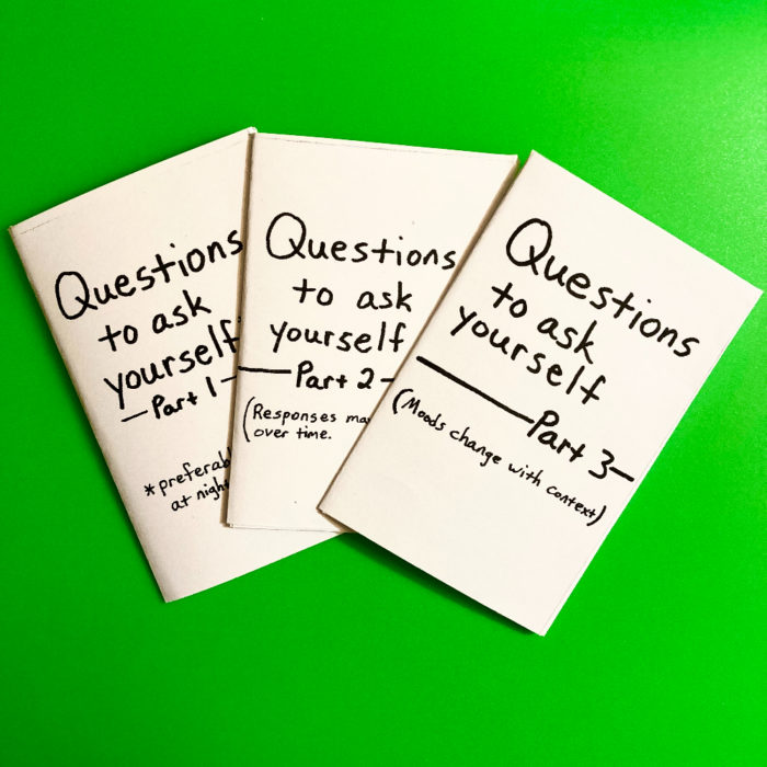 Three mini zines titled "Questions to ask yourself - Parts 1, 2, and 3." The zines are printed on white paper with black text. The background of the photo is green.