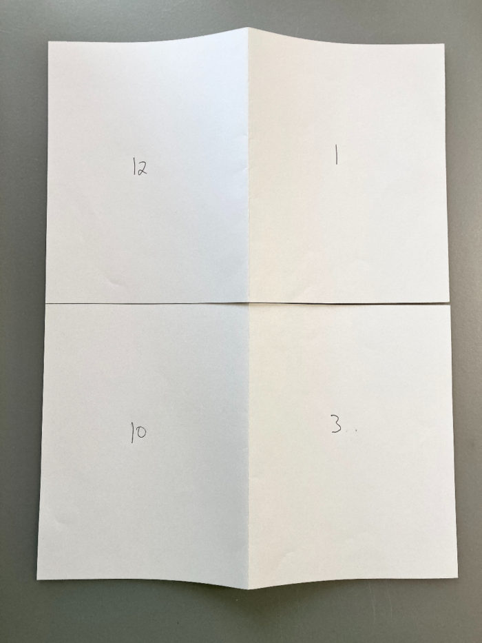 Two half-sheets of white paper with page numbers written on them. The top sheet has 12 on the left and 1 on the right. The bottom sheet has 10 on the left and 3 on the right.
