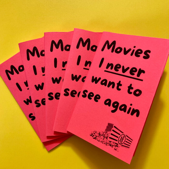 5 copies of "Movies I never want to see again" fanned out, on a yellow background.