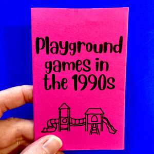 A hand holds a copy of "Playground games in the 1990s" on a blue background
